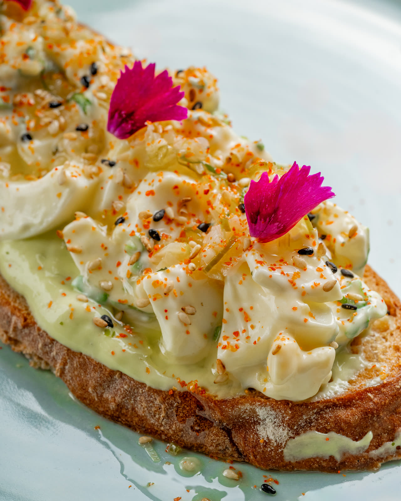 Abokado tartine with whipped avocado and edible flowers