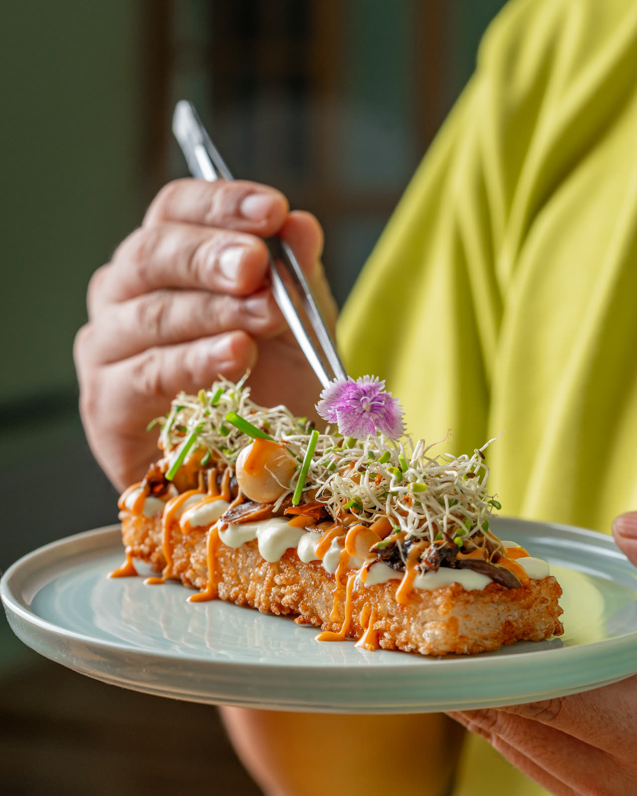 Finishing a plate with tweezers at the pass