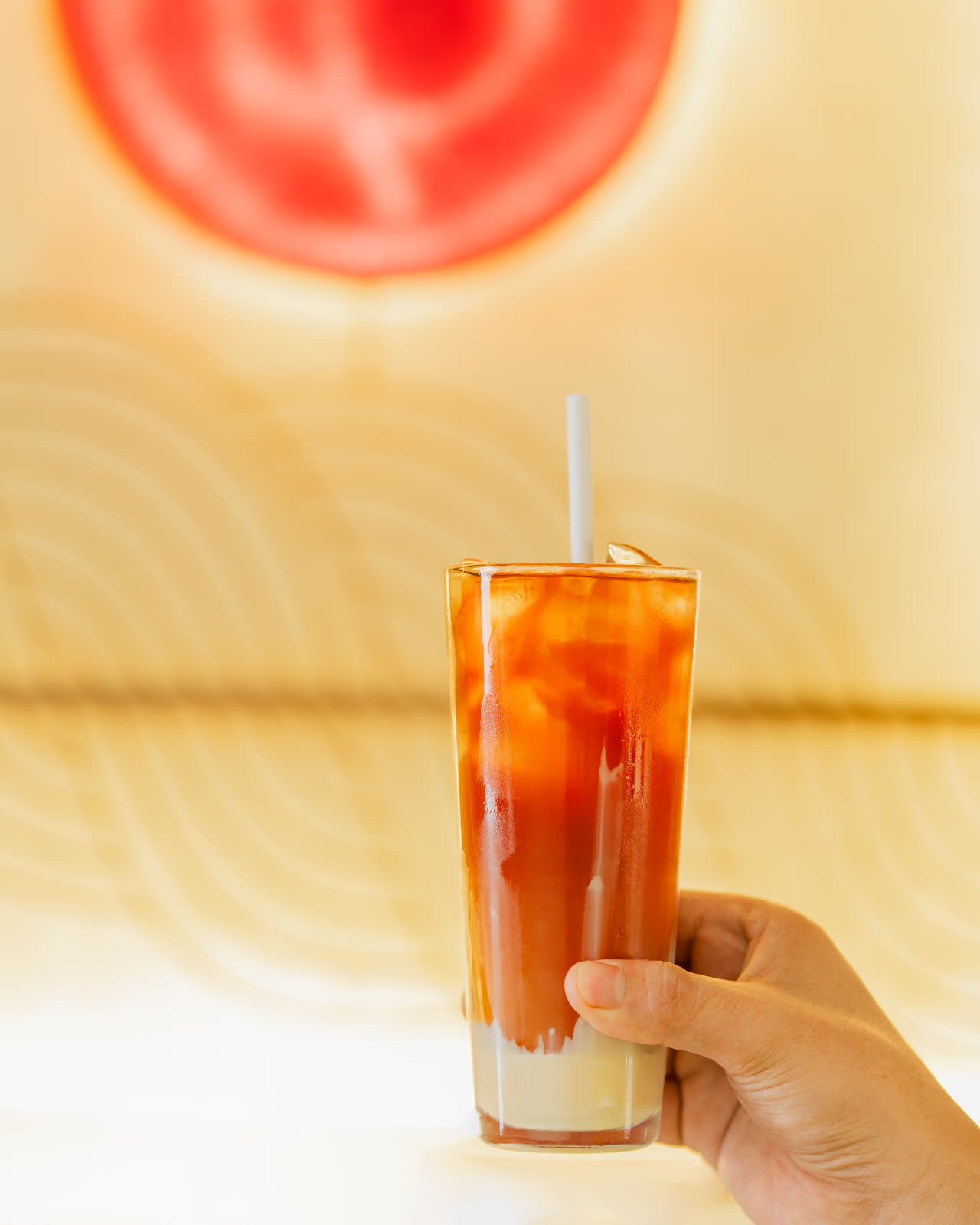 An iced coffee held under the sun panel